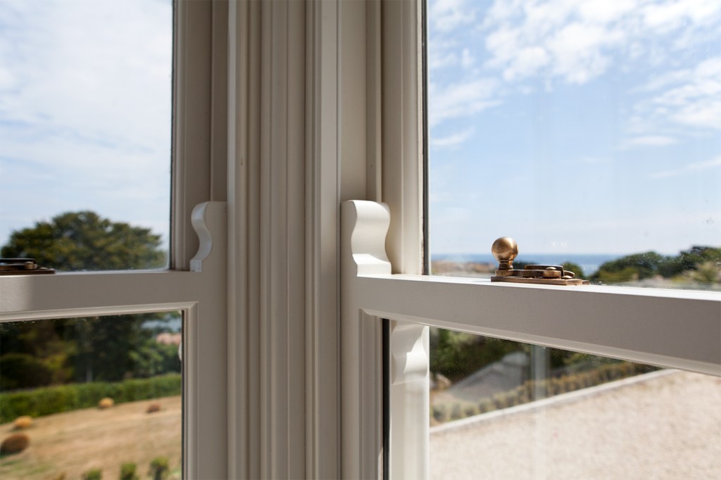 double hung window corner detail - gold latches and carved wood patterns