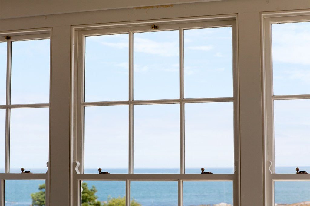 double hung windows with a ocean view - white window frame and grilles