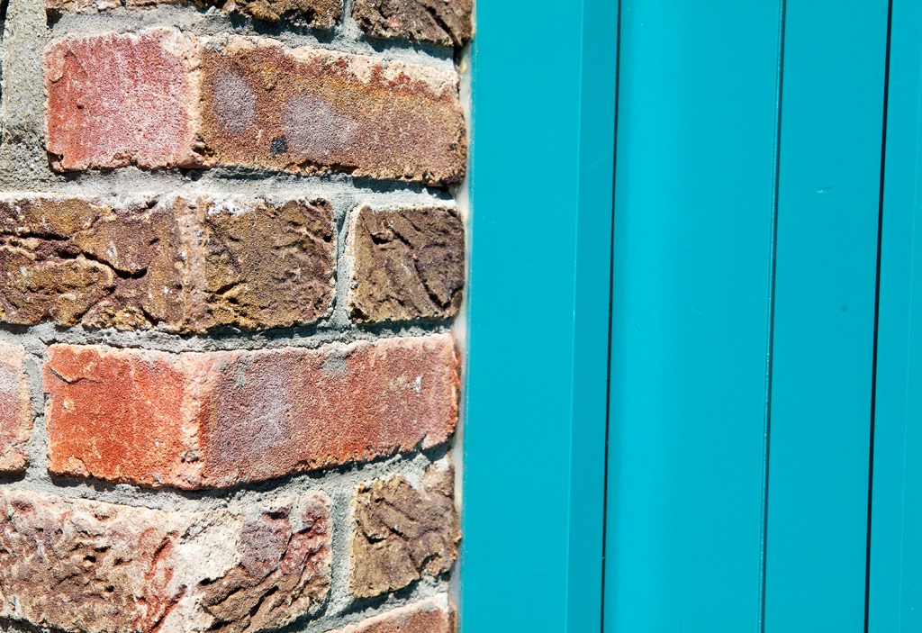 brick wall - turquoise door - door connected to brick wall