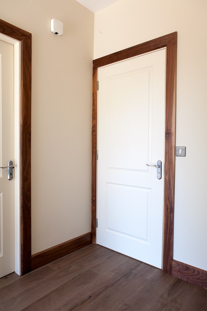 White door with dark wood door frame - laminated floor