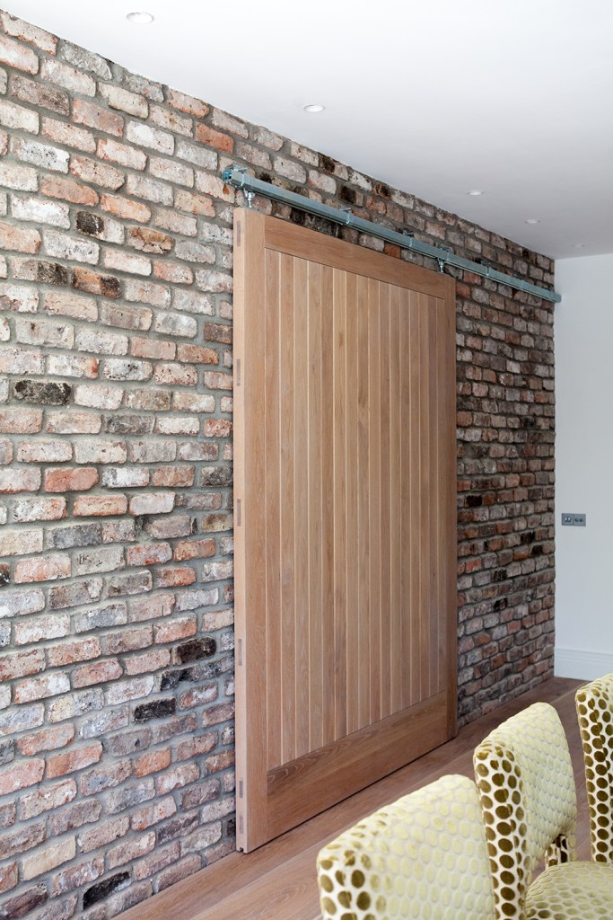 Slide door - barnyard style door - brick wall - inside door - sliding wood door - dining chairs