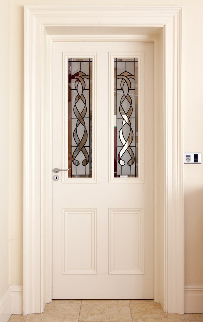 White door and frame with black detailed stained glass