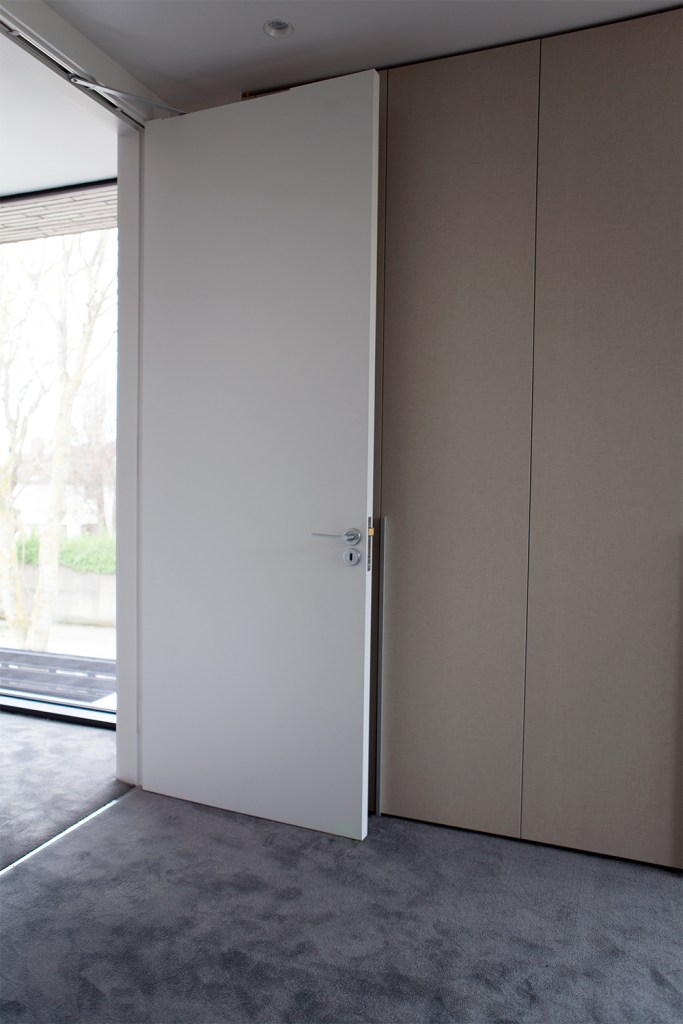 Open white door - top jamb mount - tall cupboards - silver door handle - window walls