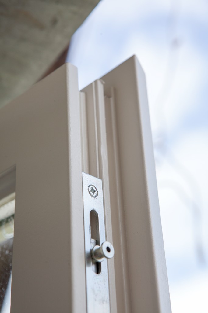 close up of a window corner - window latch - white window frame - open window