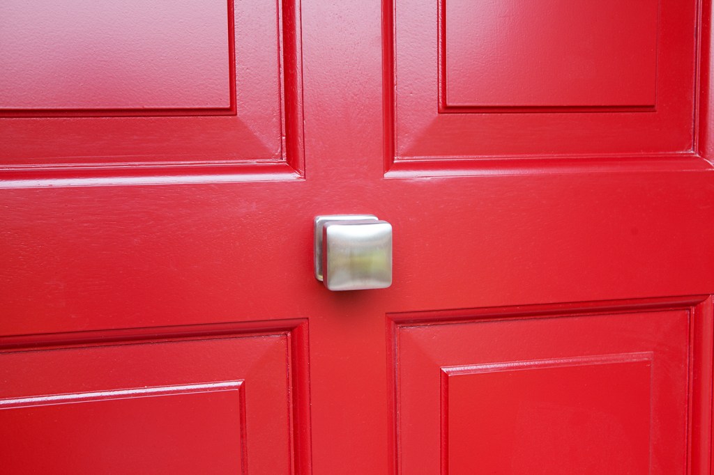 Red door with aluminum door knocker and handle