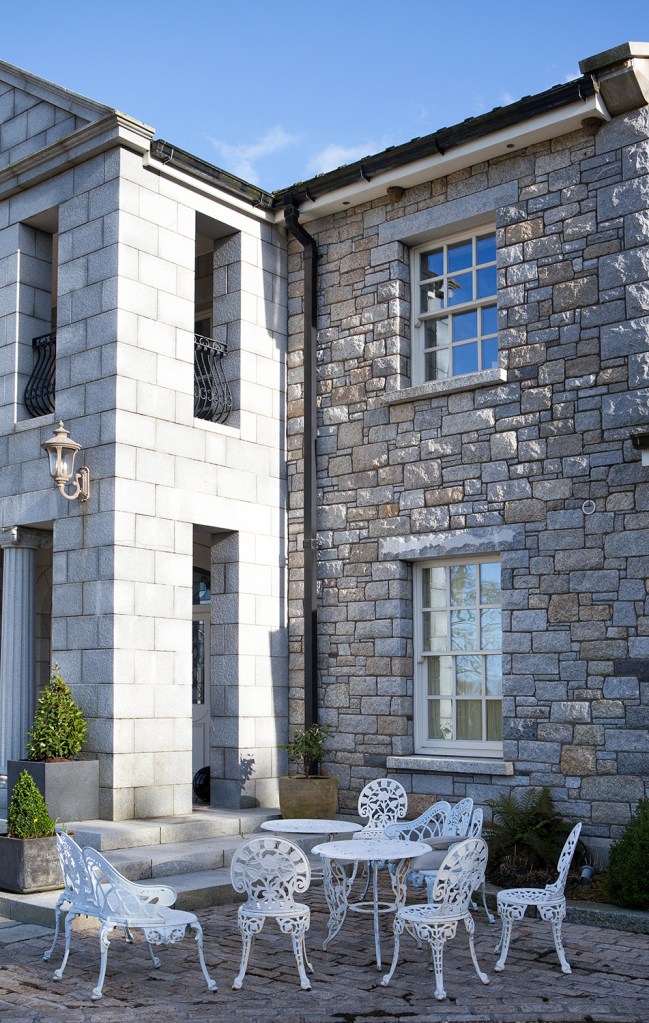Stone double story house with garden furniture - outside table and seats - white outside furniture