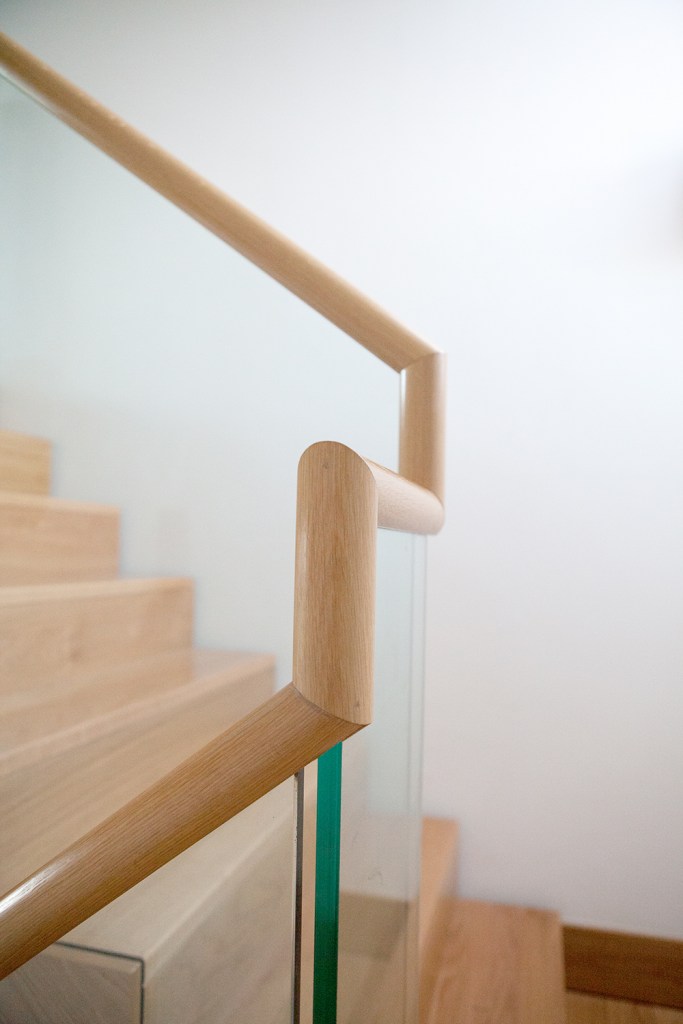Staircase handrail curves - glass baluster - light wood handrail