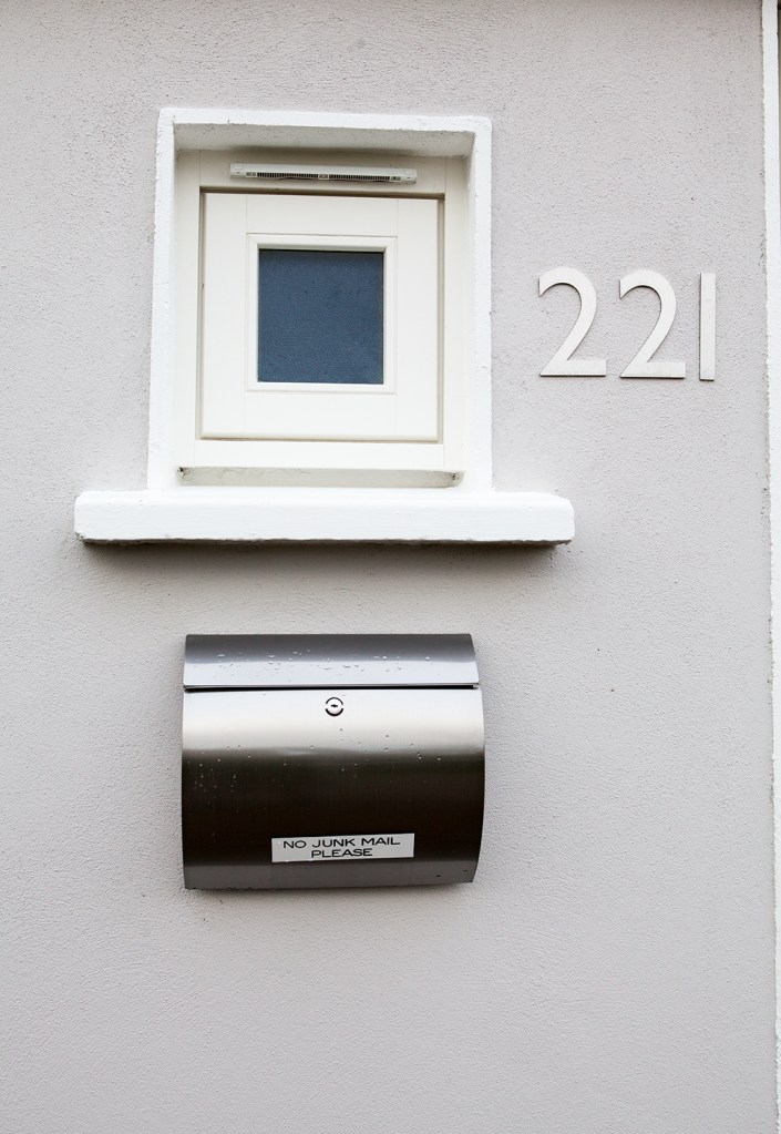 White frame around package and mail receiver - silver mailbox - number 221 - white apron on receiver box