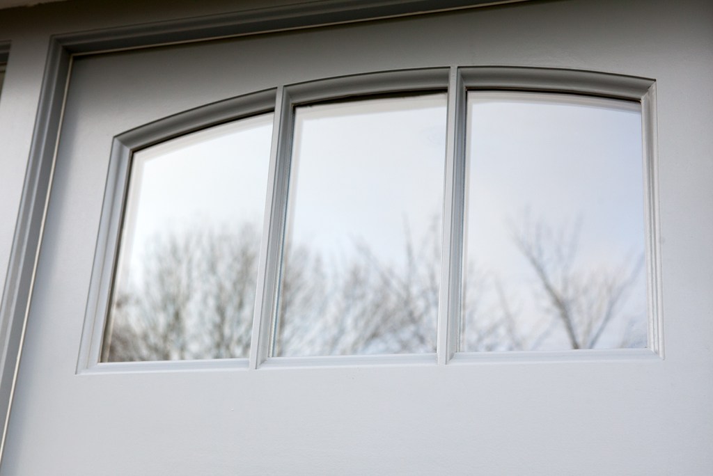 Light grey door with small window at top - window with grilles - white door frame