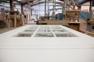 White door laying flat with small glass windows in workshop